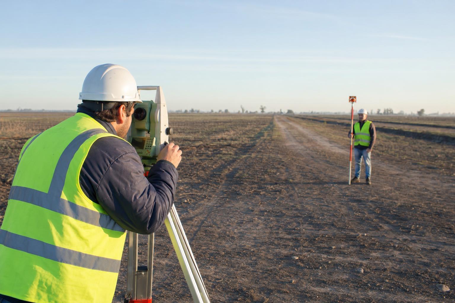 Topógrafo operando una estación total en un terreno abierto